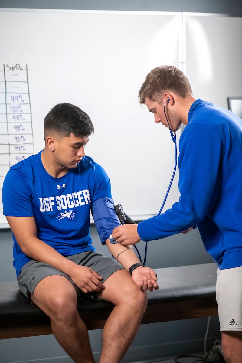 Health & Exercise Science Students demonstrate blood pressure cuff