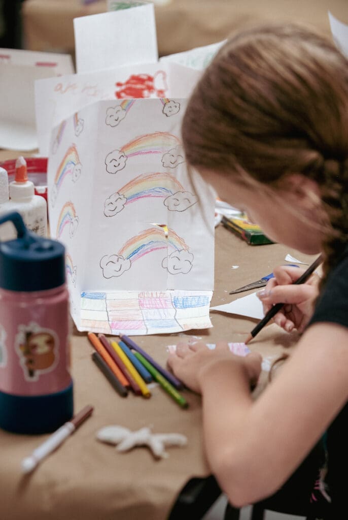Art camp students drawing rainbows