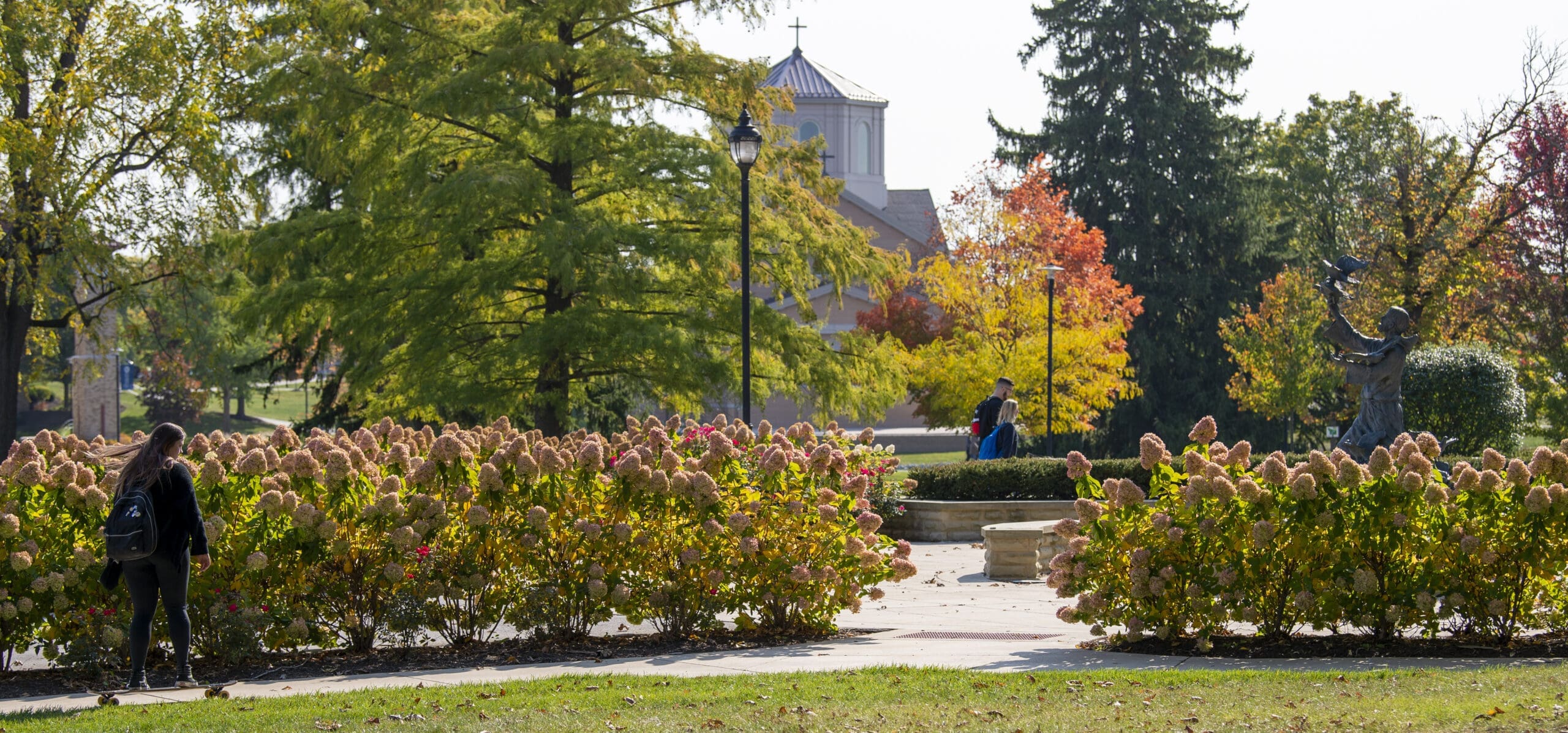 Students in the distance enjoying a nice day outside on campus.