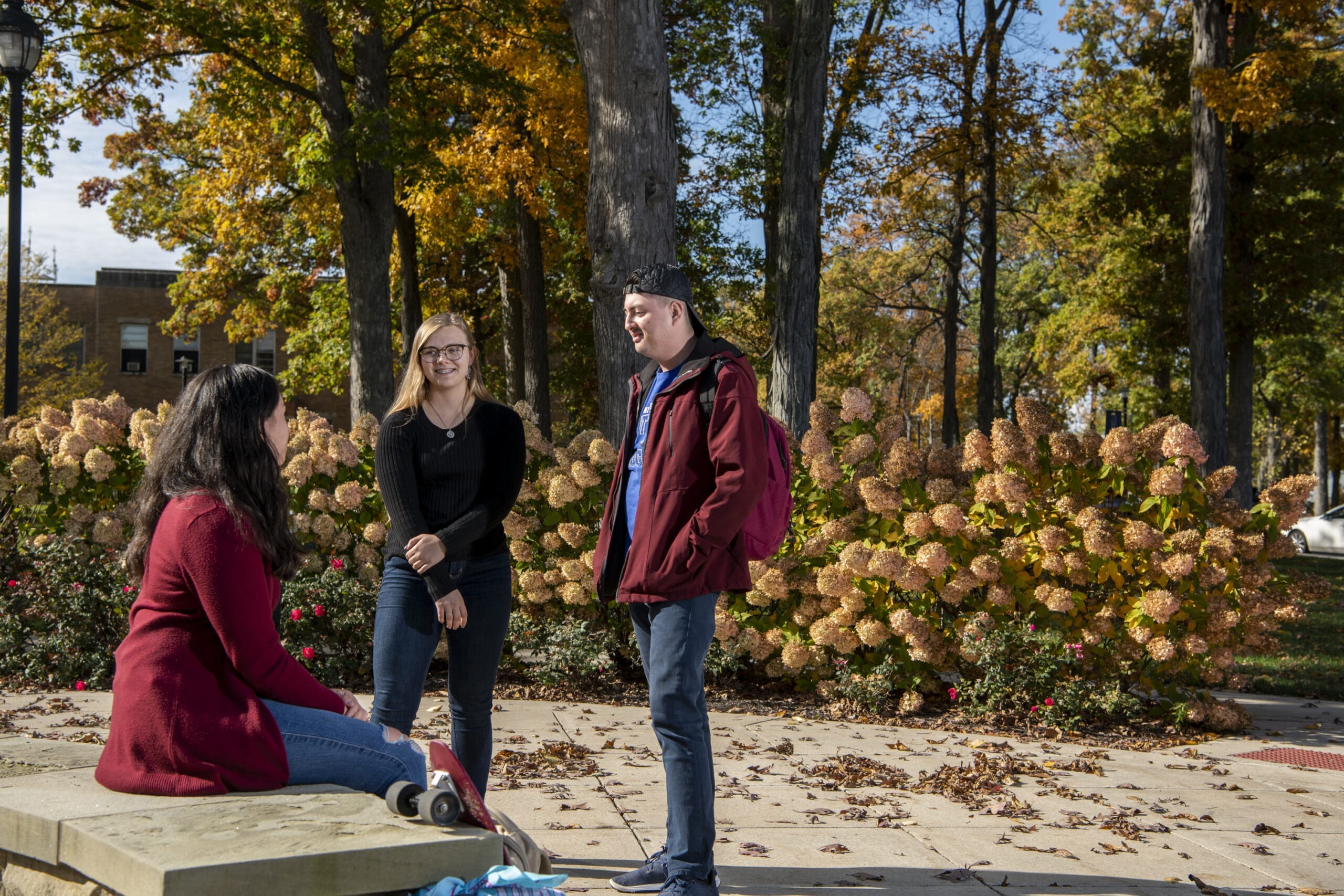 Students talking outside enjoying the fall weather on campus.