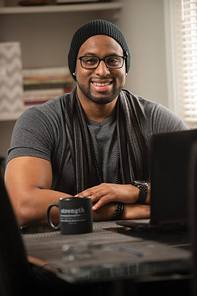 Animation alum Josh Bullock sitting at a table with a laptop in front of him