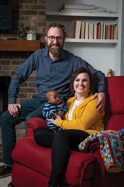 Tim and Flora Parsley holding baby Sada in their living room in Fort Wayne