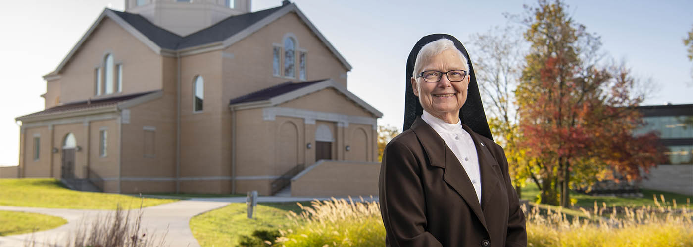 Change Agent: Sr. Elise Kriss standing in front of St. Francis Chapel
