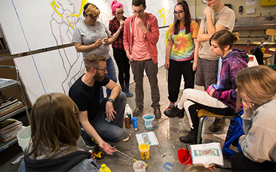 students working with professor Parsley on mural